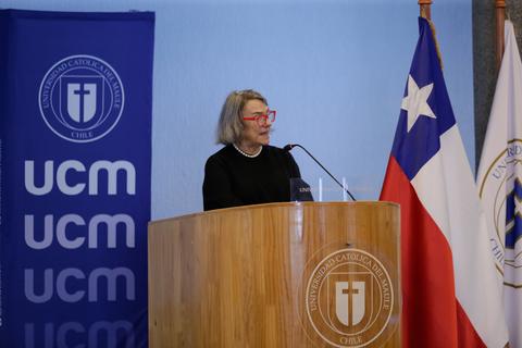 Una mujer está dando una charla en la Universidad Católica de Chile.