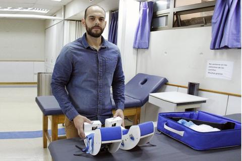 Un hombre sostiene un dispositivo médico en un entorno clínico.