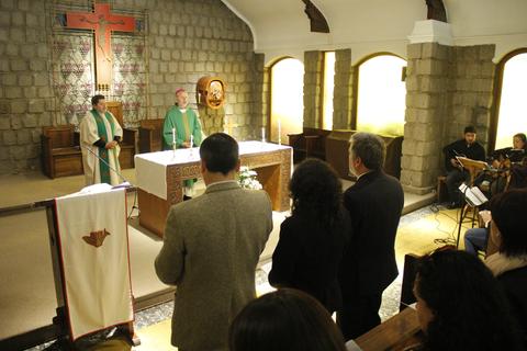 Una ceremonia religiosa en una iglesia con el altar al frente y asistentes en oración.