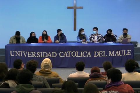 Un grupo de estudiantes se presenta en una mesa en la Universidad Católica del Maule.