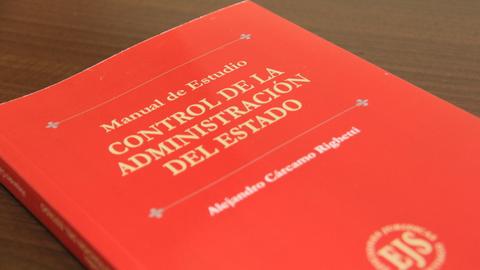 Un manual de estudio titulado 'Control de la Administración del Estado' que está sobre una mesa.