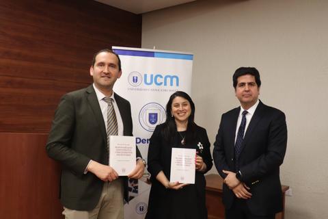 Tres personas posan con libros en un evento de la UCM.