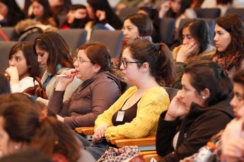 Un grupo de personas atentas escuchando en un evento o conferencia.