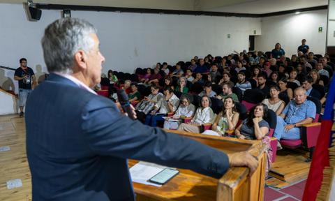 Un orador se presenta ante una multitud en un auditorio.
