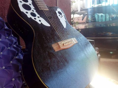 Una guitarra con un diseño distintivo y un acabado oscuro.
