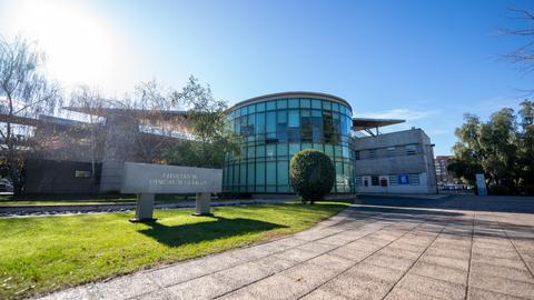 La fachada moderna de la Facultad de Ciencias de la Salud destaca en un día soleado.