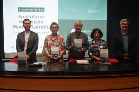 En la presentación del libro 'Epistolario del Obispo Manuel Larraín', se ve a un grupo de personas sosteniendo el texto en un evento académico.