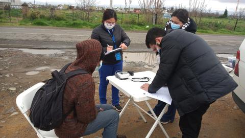Un grupo de personas realiza un chequeo de salud en la calle.