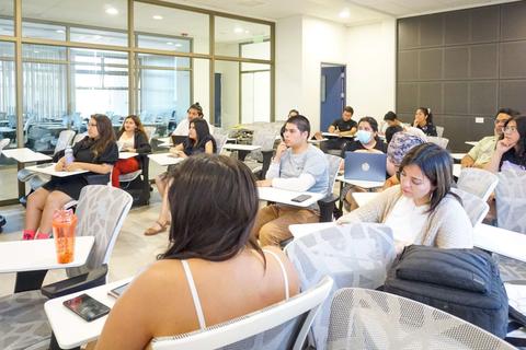 Un grupo de estudiantes atentos en un aula moderna.