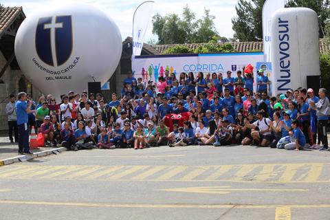 Un gran grupo de personas se reúne para participar en un evento comunitario al aire libre.