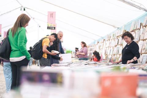 Un grupo de personas examinando libros en una feria.