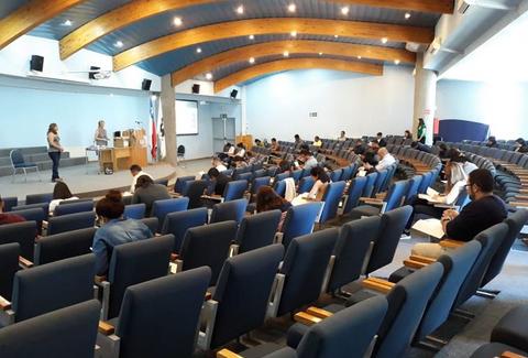 Un grupo de personas sentadas en un auditorio durante una presentación.