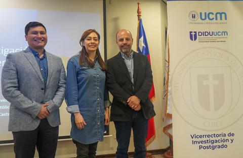 Tres personas posan en un evento académico en la Universidad Católica del Maule en Chile.