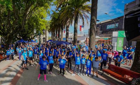 Una multitud de personas vestidas de azul celebrando en un parque.