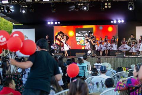 Una presentación folclórica en la Feria de Huiloapan con bailarines y un público entusiasta.