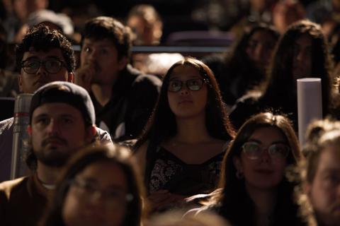 Un grupo de personas sentadas, mirando atentamente con expresión interesante en un evento.