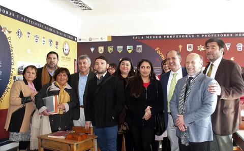 Un grupo de personas posando juntas en una sala con decoraciones relacionadas con la educación.