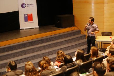 Un orador presenta un tema ante una audiencia en un auditorio.