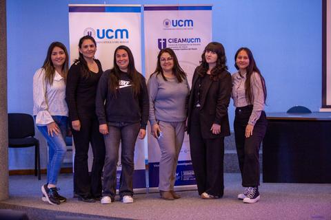 Grupo de mujeres posando en un evento en la universidad.