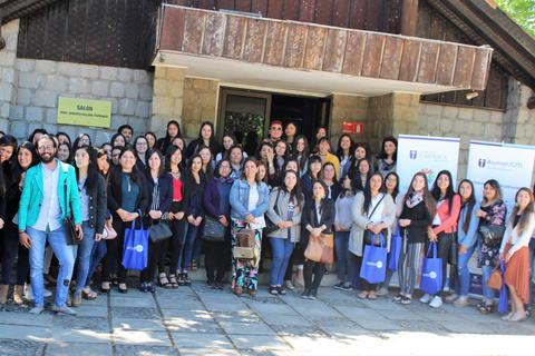 Un grupo numeroso de personas posando frente a un edificio en un evento.