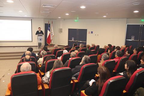 Un conferencista está presentando un tema ante un público en un auditorio.