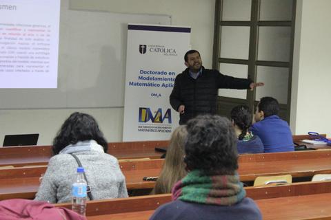 Una presentación académica frente a un grupo de estudiantes en un aula.