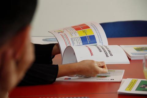Una persona está leyendo un folleto en una mesa.