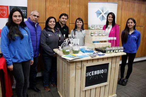 Un grupo de personas presenta productos en un stand de una feria.