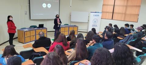 Una charla en un aula con varias personas escuchando a dos ponentes.