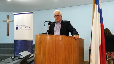 Un hombre habla desde un atril en un evento académico.