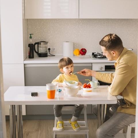 Un padre y su hijo disfrutan de un desayuno en la cocina.