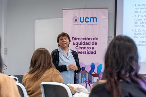 Una mujer está dando una charla en un aula sobre la equidad de género y la diversidad.