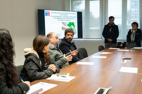 Reunión en una sala con varias personas discutiendo un plan relacionado con el medio ambiente.