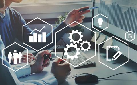 En la imagen se observa a personas analizando datos y gráficos en un entorno de trabajo moderno.