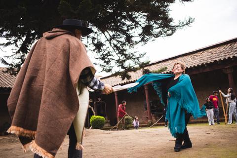 Un par de personas bailando al aire libre, vestidas con trajes típicos chilenos y disfrutando de la tradición.