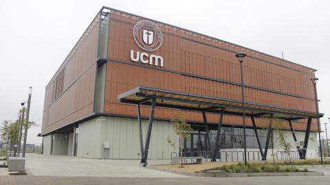 La imagen muestra un moderno edificio de la UCM con un diseño arquitectónico innovador.