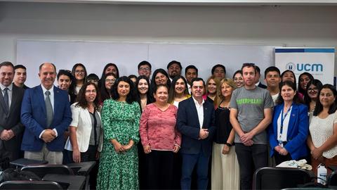 Un grupo de personas posando juntas en un evento en una aula.