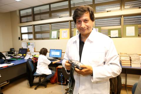 Un médico sostiene un dispositivo en un entorno de oficina médica.