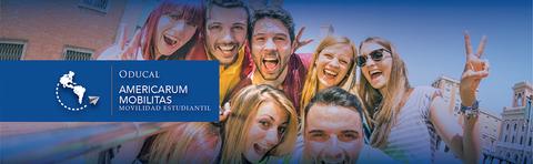 Un grupo de jóvenes sonrientes posa para la cámara, mostrando una actitud entusiasta en un ambiente urbano.