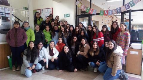 Un grupo grande de mujeres posando juntas en un espacio interior.