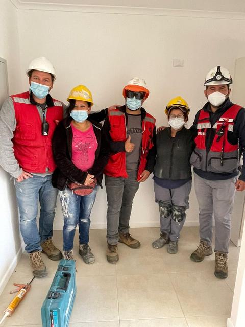 Un grupo de trabajadores de la construcción posando juntos en un lugar de trabajo.