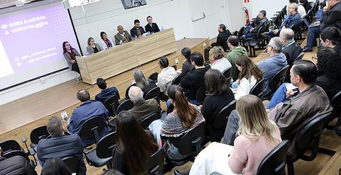 Una charla en un auditorio con varios asistentes y un panel de expositores.