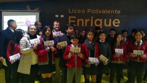 Un grupo de estudiantes sonrientes sostiene certificados frente a un banner del Liceo Polivalente Enrique.