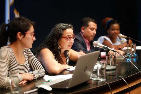 Un grupo de personas discutiendo en una mesa de conferencias.