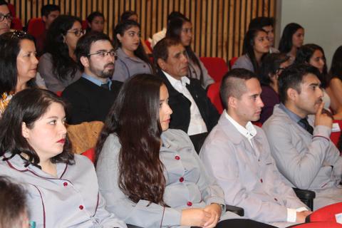 Un grupo de personas en un auditorio escuchando atentamente durante un evento.