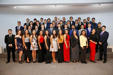 Grupo de personas posando en un evento formal.