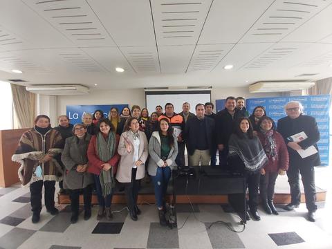 Un grupo de personas posando en un evento en un salón de conferencias.