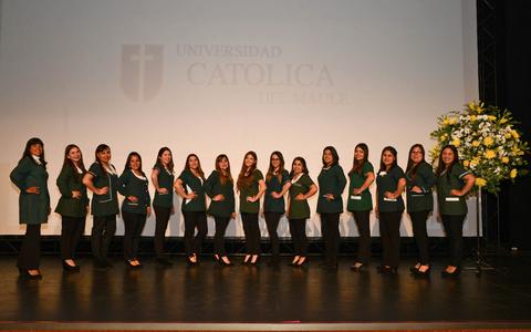 Un grupo de mujeres posando en un escenario, todas vestidas de manera formal con chaquetas verdes y pantalones oscuros.