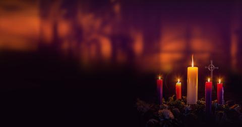 Un conjunto de velas encendidas en un ambiente oscuro y cálido.