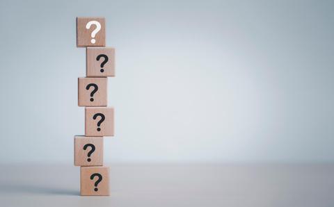 Una torre de bloques de madera con signos de interrogación.